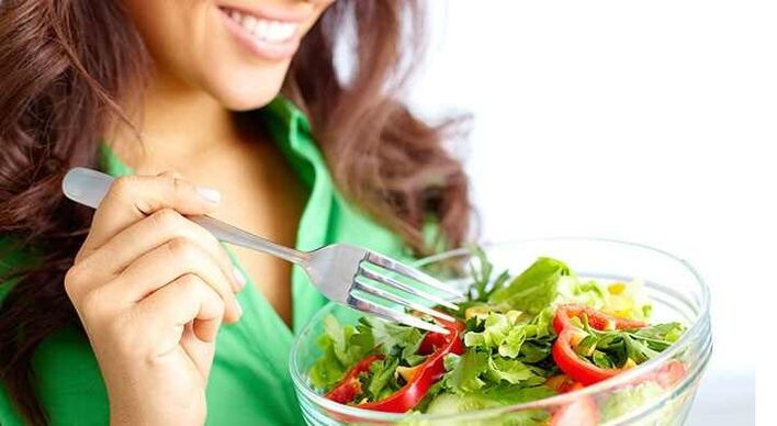 The girl eats a vegetable salad and follows a protein diet